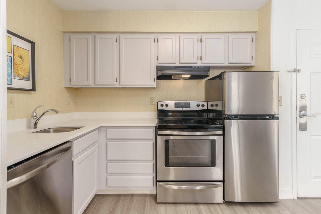 a kitchen with stainless steel appliances and white cabinets